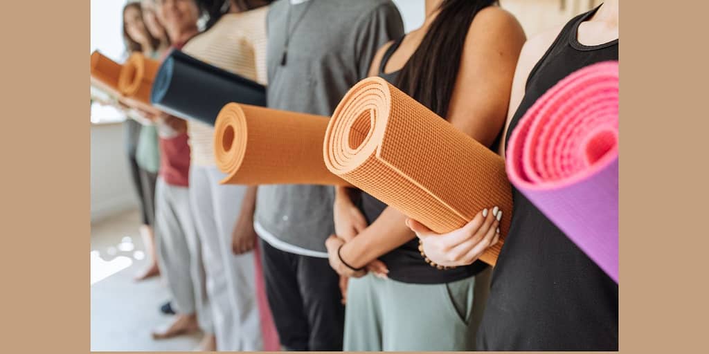 Holistic living path top 6 supreme yoga mats from amazon and they're importance for a well-rounded practice image of a Group of People Holding Rolled Up Yoga Mats.
