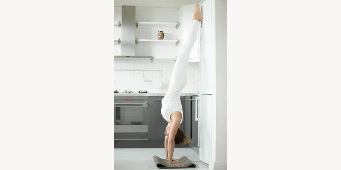 Woman doing a downward standing tree pose.