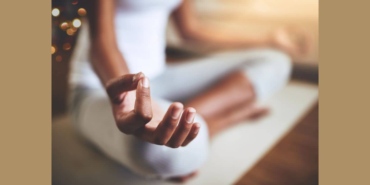 8 powerful and amazing mindfulness energy techniques woman with hand on her knee, meditating.