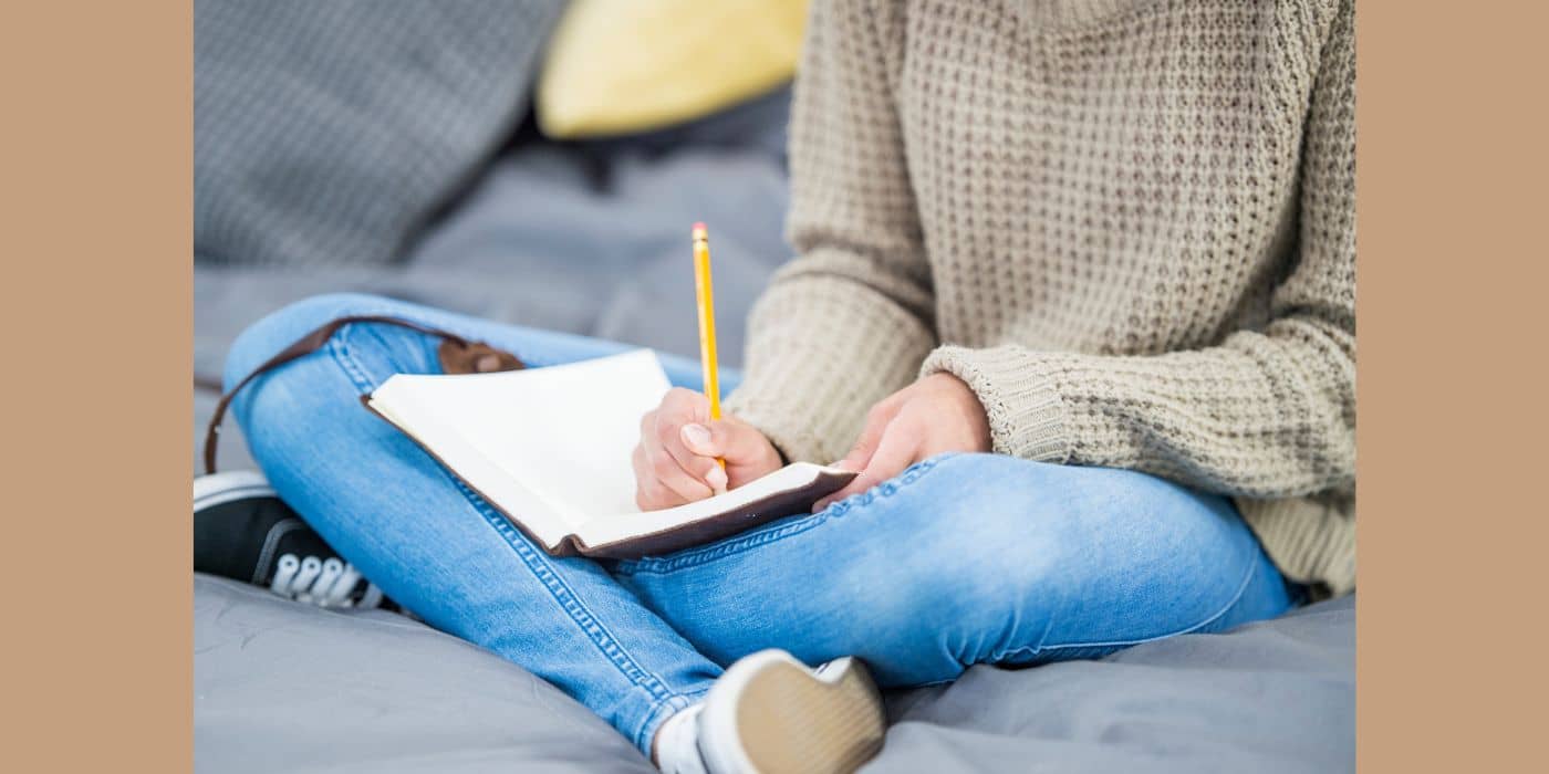 Person in biege shirt journaling.
