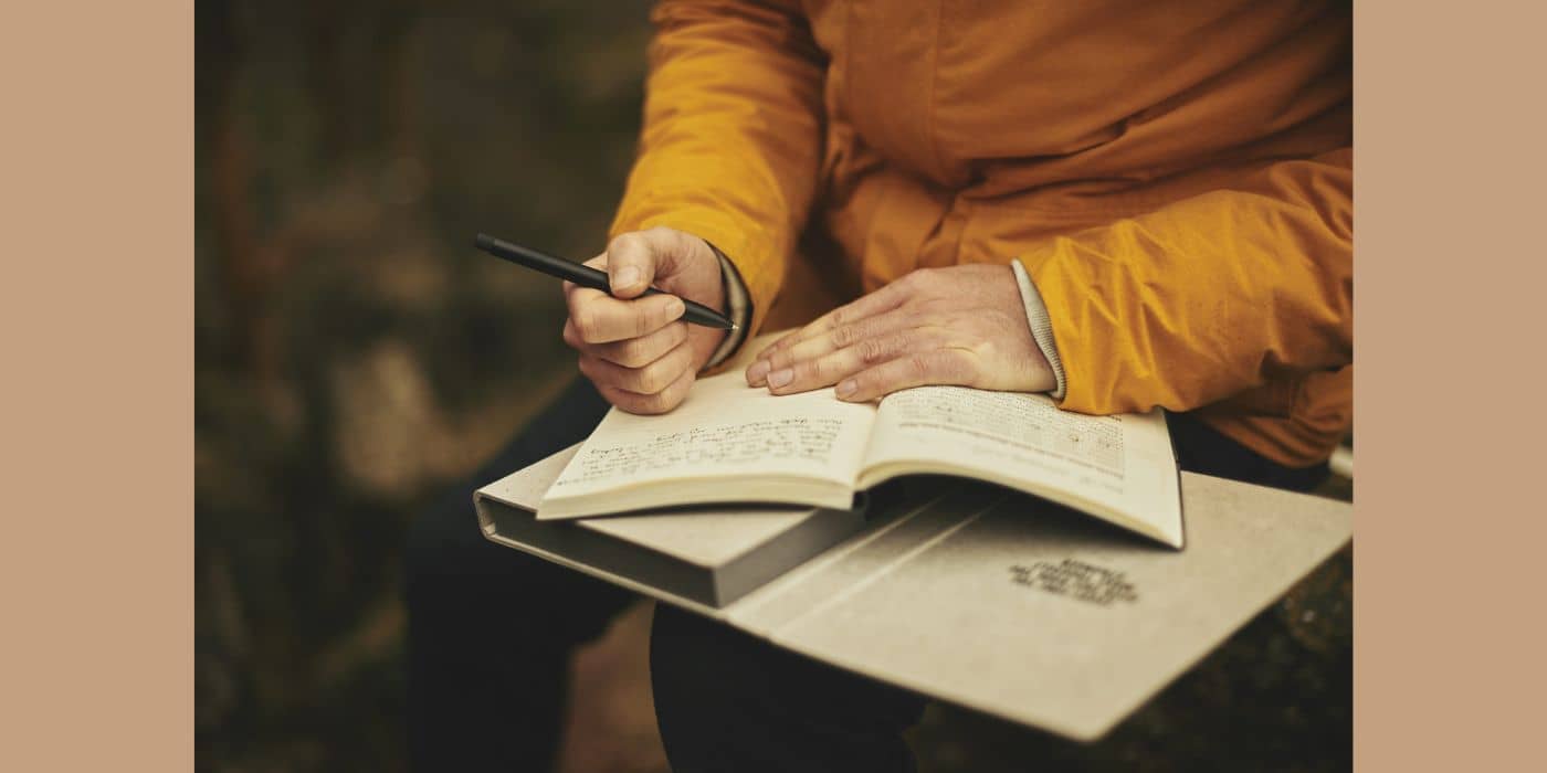 Person in orange shirt journaling.
